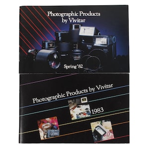 Peut inclure: Deux brochures en noir et blanc annonçant des produits photographiques Vivitar. La brochure du haut présente un groupe d'appareils photo et d'objectifs avec le texte "Photographic Products by Vivitar" et "Spring '82". La brochure du bas présente un groupe plus petit d'appareils photo et d'objectifs avec le texte "Photographic Products by Vivitar" et "1983".