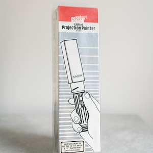 Może przedstawiać: Biały i srebrny podświetlany wskaźnik projekcyjny z napisem "COAST" na boku. Opakowanie zawiera napis "coastar Lighted Projection Pointer B-387" oraz "FOR DISTANCES UP TO 16 1/2 FEET. 2 "C" BATTERIES (NOT INCLUDED)"