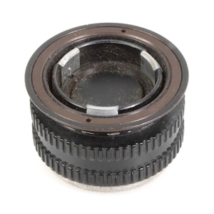 Puede incluir: Un adaptador de lente de cámara negro y marrón con un exterior estriado. El adaptador tiene un diseño circular con una abertura central y un anillo marrón alrededor de la parte superior. El adaptador de lente está diseñado para conectar diferentes lentes de cámara.