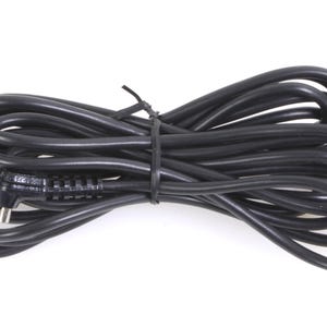 May include: A black electrical cord with a connector on one end. The cord is coiled and tied with a black zip tie.