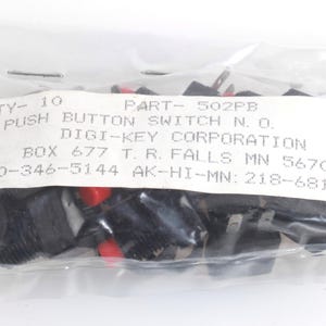 Può includere: Un sacchetto di plastica trasparente contenente dieci interruttori a pulsante neri con dettagli rossi. Gli interruttori sono etichettati con testo tra cui "PUSH BUTTON SWITCH N. O." e "DIGI-KEY CORPORATION".
