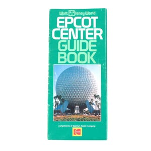 May include: A vintage EPCOT Center Guide Book from Walt Disney World. The cover is green with white text, including "EPCOT CENTER GUIDE BOOK." The cover features a photo of Spaceship Earth. The book is a souvenir.
