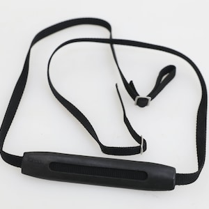May include: Black camera strap with a padded handle and adjustable length.