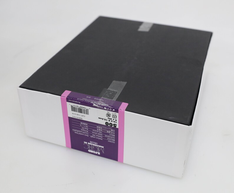 以下が含まれることがあります： 黒色の蓋が付いた白い箱。箱には、「ILFORD MULTIGRADE FB」と「500」の文字が印刷された紫と白のラベルが付いています。ラベルには、バーコードと製品に関するその他の情報も含まれています。