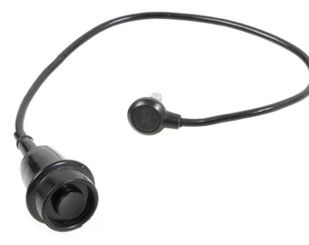 以下が含まれることがあります： ボタンと接続ワイヤーを備えた黒色の電気部品。この部品は、片側にボタン、もう一方に小さな円形部分があり、柔軟な黒いワイヤーで接続された円形デザインです。