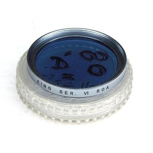 May include: A blue filter for a camera lens with the text "KING SER. VI 80A" around the edge.