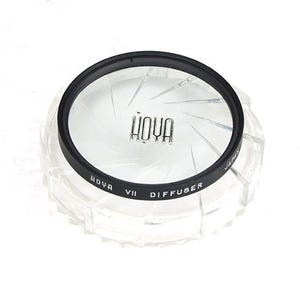 May include: A black and clear Hoya VII diffuser filter for photography. The filter has a starburst pattern and the text "HOYA VII DIFFUSER" printed on the edge.