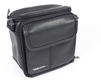 May include: Black leather camera bag with a zip closure and a Case Logic logo.