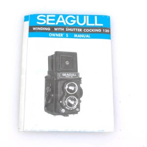 May include: Black and white instruction manual for a Seagull camera with a shutter cocking 120. The cover features a photo of the camera.
