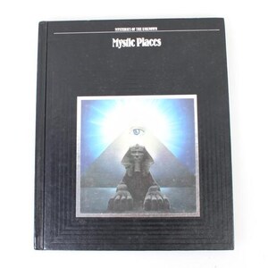 May include: A black book titled "Mystic Places" featuring an illustration of a sphinx, pyramid, and an eye. The image is framed in silver against a blue and white backdrop. The book is part of the "Mysteries of the Unknown" series.