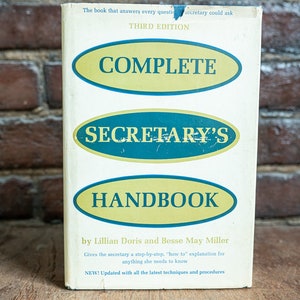 Può includere: Un libro bianco con una copertina gialla e blu. Il titolo è "Complete Secretary's Handbook" con le parole "Complete" e "Handbook" in ovali gialli e "Secretary's" in un ovale blu. Il libro è di Lillian Doris e Besse May Miller. Il libro è una terza edizione ed è stato aggiornato con le ultime tecniche e procedure.