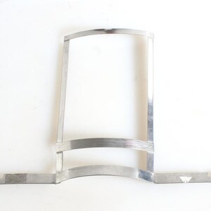 May include: A silver metal frame with a curved top and two horizontal bars. The frame has two straight arms extending from the bottom.