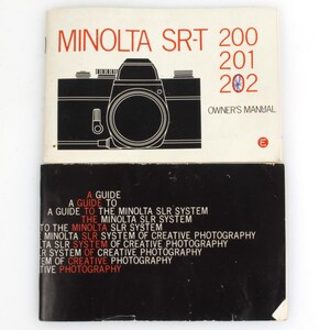 Può includere: Manuale del proprietario della fotocamera Minolta SRT-200 vintage. La copertina presenta un'illustrazione in bianco e nero della fotocamera e il testo "MINOLTA SRT-200 201 202 OWNER'S MANUAL". La parte inferiore del manuale è nera con testo bianco e rosso.