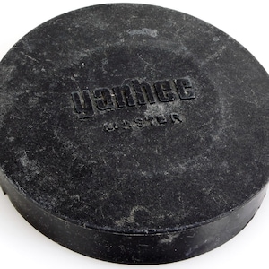 Puede incluir: Tapa de lente redonda negra con el texto "Vahtec Master" impreso en ella.