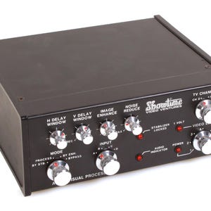 May include: Black Showtime Video Ventures visual processor with multiple knobs and dials. Features include H Delay Window, V Delay Window, Image Enhance, and Noise Reduce. The device has a power indicator and TV channel controls.