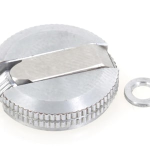 Puede incluir: Un sacapuntas plateado con un borde estriado y una pequeña arandela separada. El sacapuntas tiene una cuchilla rectangular y un cuerpo circular. Los artículos están sobre un fondo blanco.