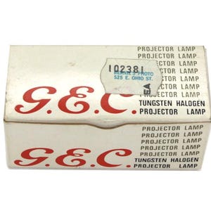 Puede incluir: Una caja blanca con letras rojas que dicen "G.E.C." y "TUNGSTEN HALOGEN PROJECTOR LAMP". La caja tiene una pegatina con el texto "102381" y "BERNIE'S PHOTO 525 E. OHIO ST."