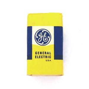 Peut inclure: Une boîte jaune avec une bordure bleue et le logo de General Electric. Le texte "GENERAL ELECTRIC" et "U.S.A." est imprimé sur la boîte.