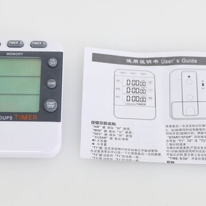 May include: A white digital kitchen timer with a green display and three separate timers. The timer has buttons for hours, minutes, seconds, start, stop, clear, and on/off. The timer also has a memory function. The timer is labeled "3 Groups Timer".