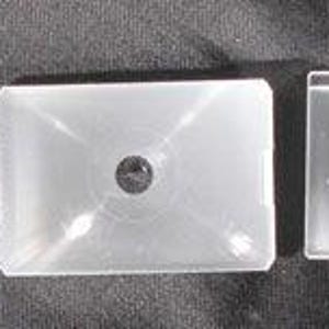 May include: Five rectangular, clear glass objects with a circular hole in the center. The objects are arranged in a row, with the last one having a dark border. The objects appear to be lens filters or similar optical components.