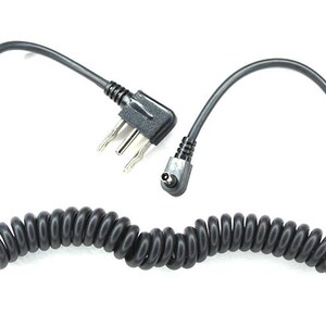 May include: Black coiled cable with a three-prong plug and a small angled connector. The cable is designed with a coiled section and straight sections at each end, all against a white background.