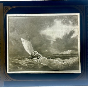 Puede incluir: Imagen en blanco y negro de un velero en una tormenta. El barco está inclinado en las turbulentas aguas. El marco incluye el texto: "England-London-A Galiot in Gale by John S. Cotman."