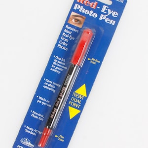 Könnte beinhalten: Ein Pioneer Red-Eye Foto-Stift auf einer blau-weißen Verpackung. Der Stift hat eine rote Kappe und einen schwarzen Schaft. Die Verpackung enthält den Text "Entfernt die meisten rote Augen von Farbfotos" und "Neu! Dual Point."