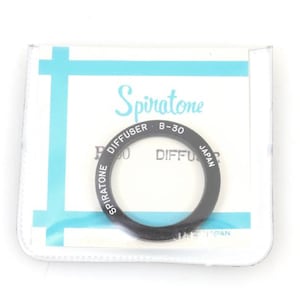 May include: A black Spiratone diffuser ring, model B-30, with white lettering, inside a white and blue package. The ring is labelled "DIFFUSER" and "JAPAN". The package has the Spiratone logo.