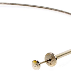 May include: A silver flexible cable with a round metal handle at one end. The handle has the text "K.D.D.  PAT.  PEND."  The other end of the cable has a small round metal piece with the number "5" on it.