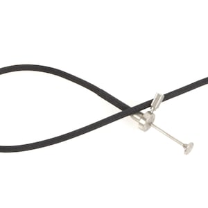 Puede incluir: Una manguera de goma negra con un conector de metal plateado y una pequeña punta de metal plateado.