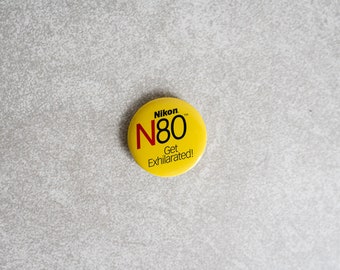 Żółta przypinka Nikon N80 - Rozkoszuj się!