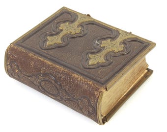 Puede incluir: Libro antiguo encuadernado en cuero marrón con detalles dorados. La cubierta presenta diseños dorados y un borde decorativo. Los bordes de las páginas están dorados y el libro parece bien conservado. Un objeto de colección.