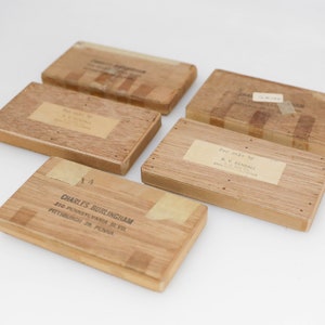 Puede incluir: Cinco cajas de madera con etiquetas. Las cajas son de diferentes tamaños y tienen diferentes etiquetas. Las etiquetas están todas escritas a mano y tienen información diferente. Las cajas son todas de madera y tienen un acabado natural.