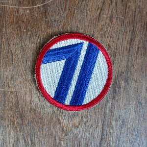 以下が含まれることがあります： 白、青、赤の刺繍が施されたパッチで、白い背景に青い数字「71」が書かれています。パッチは赤い縁取りで囲まれています。