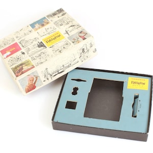 Könnte beinhalten: Ein brauner Karton mit blau-weißem Innenraum. Auf der Vorderseite der Schachtel ist ein Bild von Menschen am Strand und der Schriftzug "Flashfun" zu sehen. Die Schachtel ist geöffnet und der Innenraum ist sichtbar.