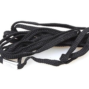 May include: A black cord or rope, coiled and tied in a knot. The cord is about 1.5 inches wide.