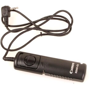 May include: A black Canon RS-60-E3 remote shutter release with a black cable and a 3.5mm jack. The remote has a button for taking photos and is designed for Canon cameras.