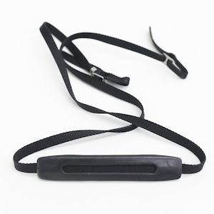 May include: Black camera strap with a padded handle. The strap is made of nylon and has metal clasps.