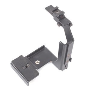 Op de afbeelding: Zwart metalen camera-accessoire met een montagebeugel en verstelbare arm. Het accessoire heeft een rechthoekige basis en een verticale arm met een flitsschoen. Het is ontworpen om aan een camera te bevestigen.