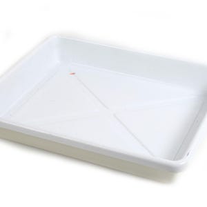 May include: A white rectangular tray with slightly raised edges. The tray has a smooth surface and a subtle geometric pattern on the interior. The corners are rounded, and the overall design is simple and functional.