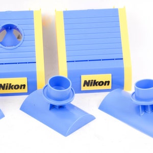 May include: Three blue and yellow plastic camera lens cleaning tools with the word "Nikon" printed on them.
