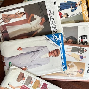 May include: A stack of vintage sewing patterns for women's clothing. The patterns are from Simplicity, Butterick, and McCall's. The patterns feature a variety of styles, including a blazer, a skirt, and a dress.