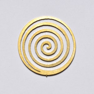 May include: A gold-coloured metal spiral design with concentric circles.
