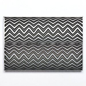May include: A rectangular, black and white patterned object with a zig-zag design. The pattern is repeated, creating a visual effect of depth and texture. The object is set against a white background.