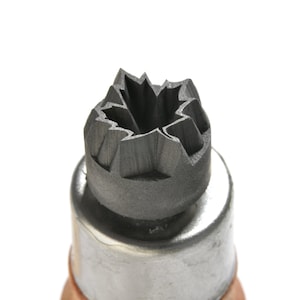 May include: A close-up of a black metal stamp with a maple leaf design. The stamp is used for creating impressions in clay or other soft materials.