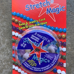 May include: A spool of clear stretch magic bead and jewellery cord. The spool is 5 metres or 16.4 feet long. The cord is 0.8 mm or 0.031 inches in diameter. The cord is strong, stretchy, and resistant. It is also flexible and durable. The packaging is red with a white star and the words "Stretch Magic" in large letters.