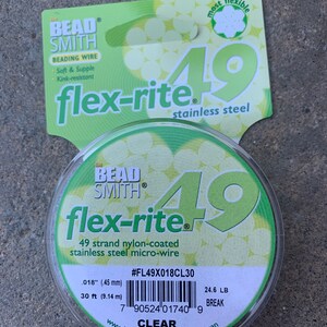 May include: A spool of clear Bead Smith Flex-Rite 49 strand nylon-coated stainless steel micro-wire. The spool is labeled with the product name, size, and material. The label also includes the product number #FL49X018CL30, a barcode, and the words "Clear" and "Made in Japan".