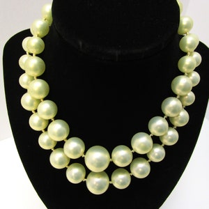 May include: A double strand pearl necklace with large, round, cream-colored pearls.
