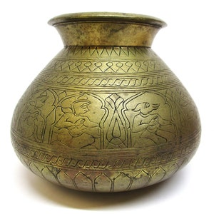 Könnte beinhalten: Ein großer, runder Wasserkrug aus Messing mit aufwendigen Schnitzereien von Figuren und geometrischen Mustern. Der Krug hat eine breite Öffnung und einen schmalen Hals.