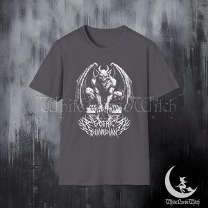 May include: Gray t-shirt featuring a white graphic of a gargoyle with the text "Gothic Guardian". The image also includes the text "White Horse Witch" in the lower right corner.